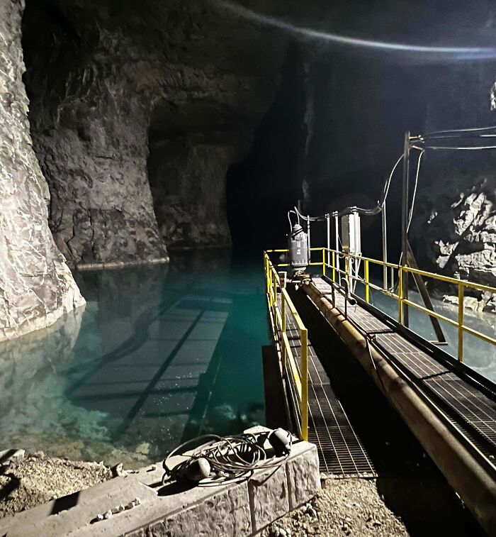 Underground industrial workspace with water and metal walkway, highlighting jobs that should pay more from unsettling worker photos.