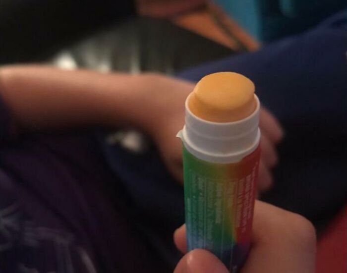 Child holding a homemade invention resembling a rainbow-colored lip balm tube showcasing creativity and smart ideas.