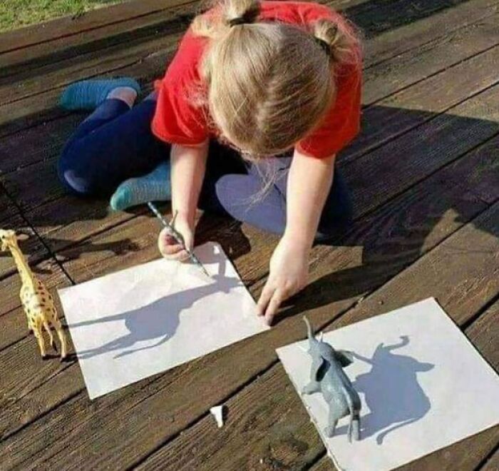 Child using shadows of toys to create drawings outdoors, showcasing creativity and inventive thinking in kids' new inventions.