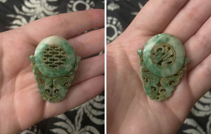 Hand holding an old green carved jade artifact with intricate patterns, found but unknown what it is.