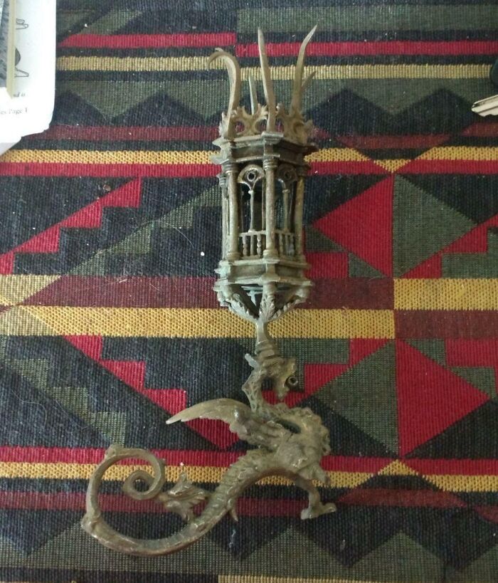 Intricately carved old metal object resembling a dragon and lantern, found item with unclear purpose shared online for identification.
