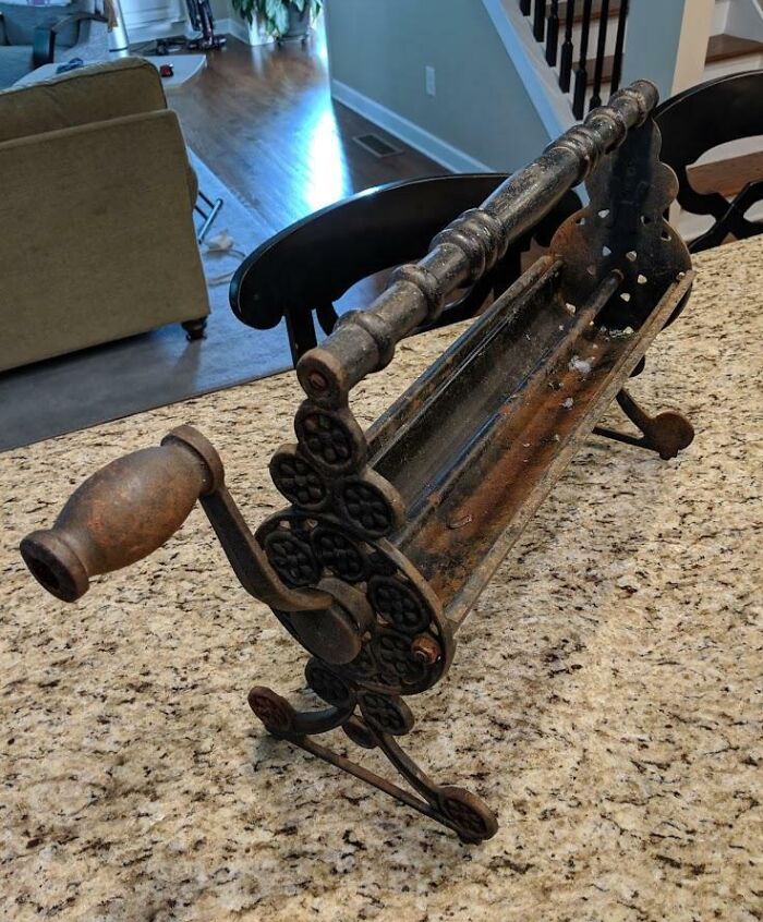 Old rusty metal kitchen tool with a wooden handle, found but unclear what it is, illustrating people finding something old.