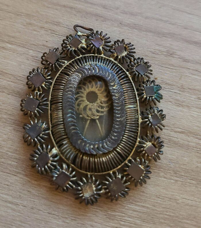 Antique ornate pendant with an intricate design, found old and mysterious, shared online for identification help.