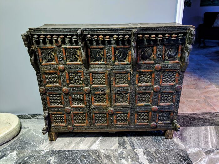 Dark wooden antique chest with intricate carvings, found old item puzzling people, explored by internet community.