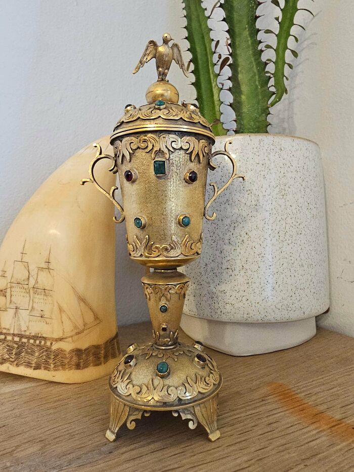 Ornate old decorative chalice with gemstones and a bird figurine on top, found by people with no clue what it was.