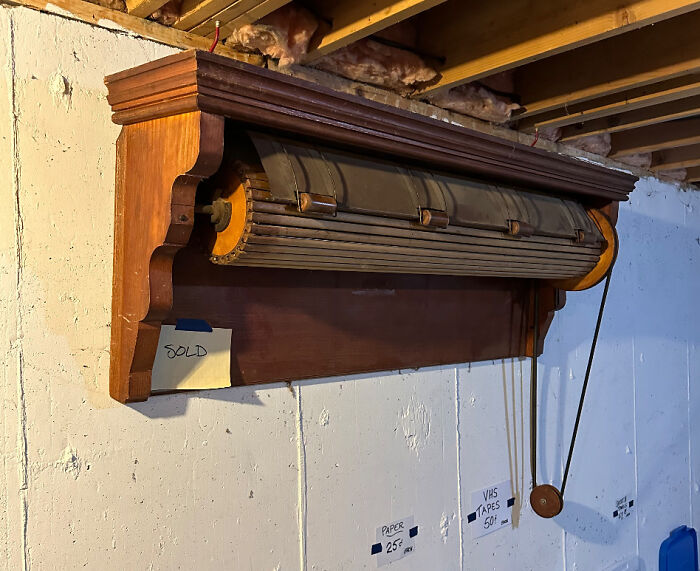 Vintage wooden window blind with pull cord in basement, an old item people found without knowing its use.