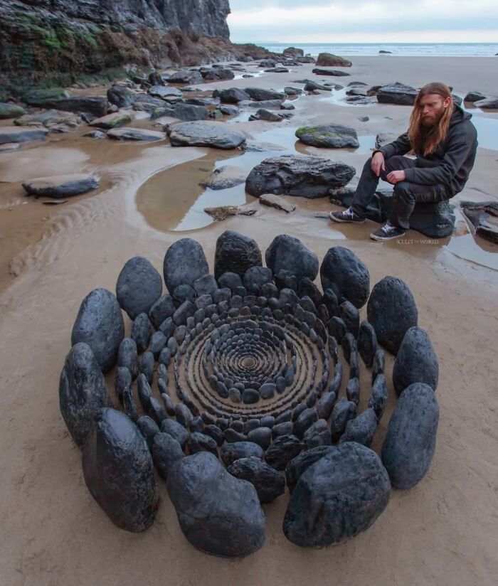Jon Foreman creating hypnotic, short-lived land art on a beach in Wales with concentric stone sculptures.