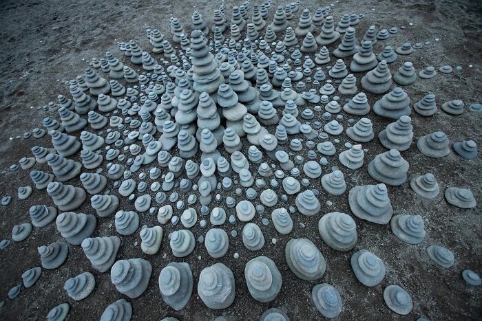 Land art on a beach in Wales featuring hypnotic stone sculptures stacked in intricate patterns by Jon Foreman.