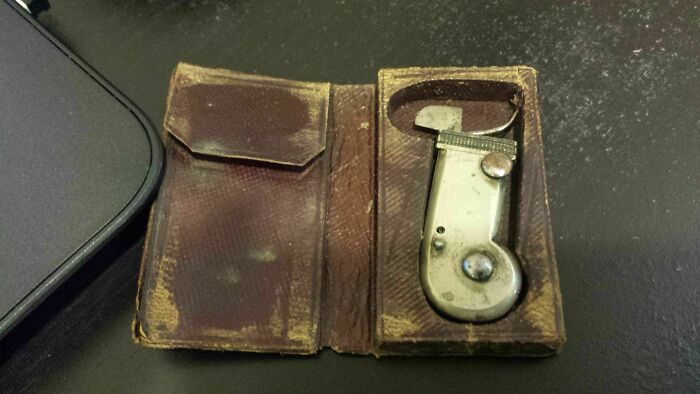 Vintage metal tool inside a worn leather case, found old object with unknown purpose, part of internet help discovery.