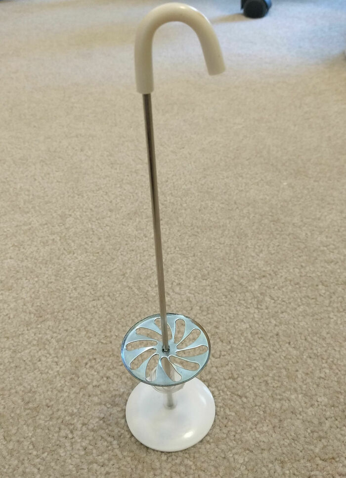 Vintage kitchen tool with a curved handle and metal disc, found old and unclear object identified by the internet community