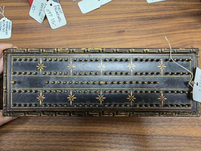 Vintage wooden counting board with brass pegs and intricate inlay, an old find puzzling people online.