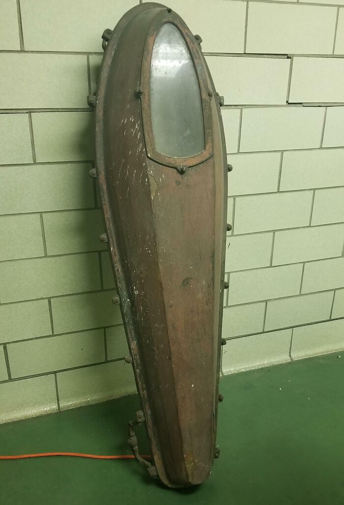Old wooden artifact with metal bolts and a glass window, an unusual vintage item found with no clue what it is.