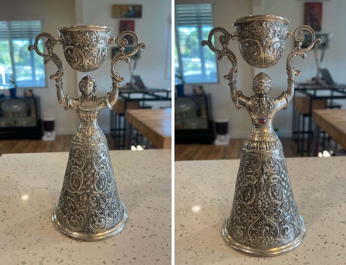 Ornate vintage silver figurine shaped like a woman holding a decorative cup, found old object with unknown purpose.