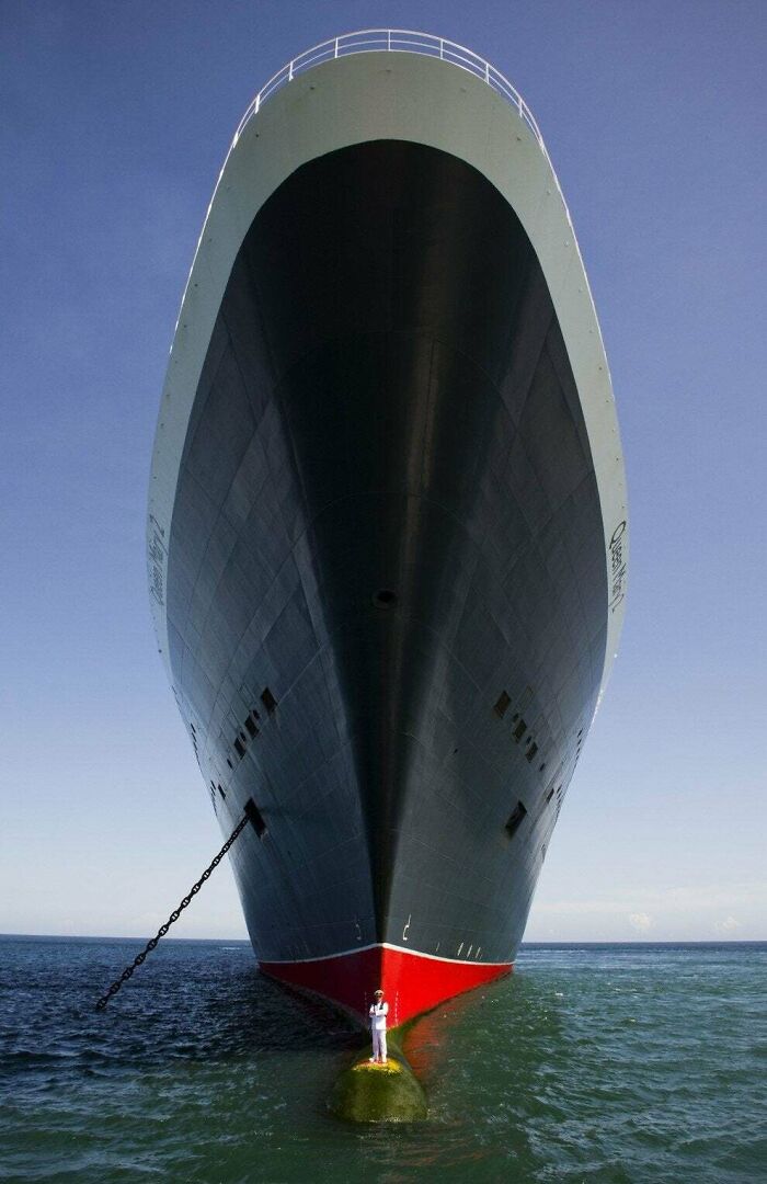 Massive ship bow towering over a person using human for scale to show the scale of things in an unusual way.
