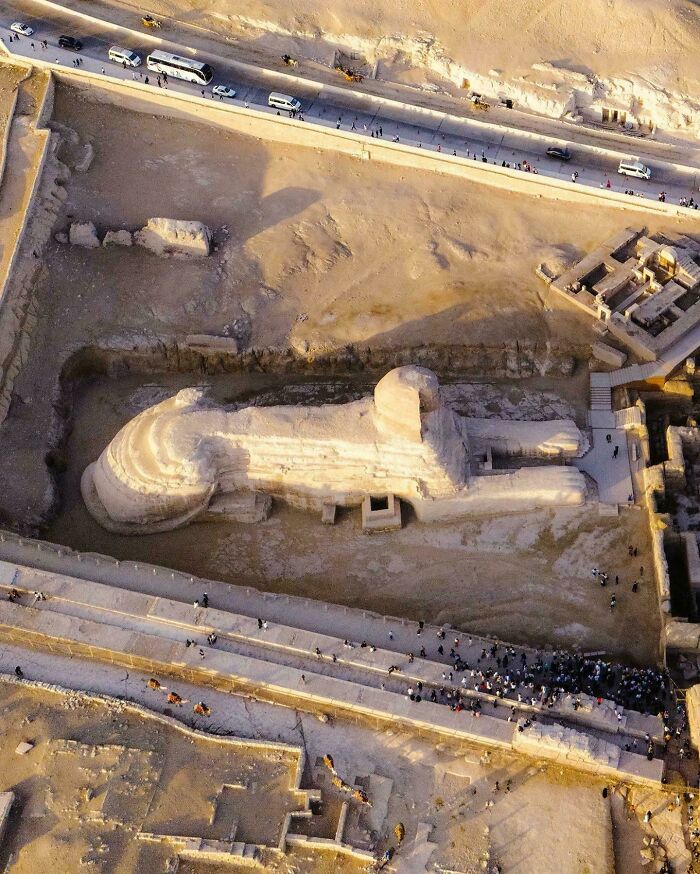 Aerial view of the Great Sphinx with humans for scale showing the massive size of the ancient monument.