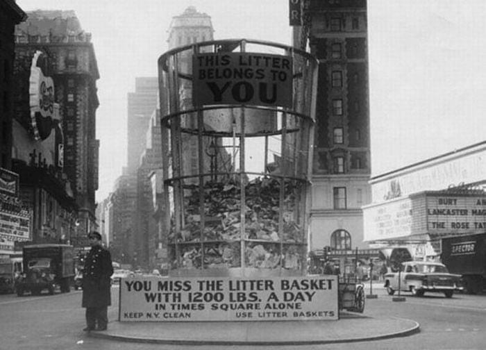 Large litter basket in a city street with a person for scale, illustrating unusual size and human for scale concept.