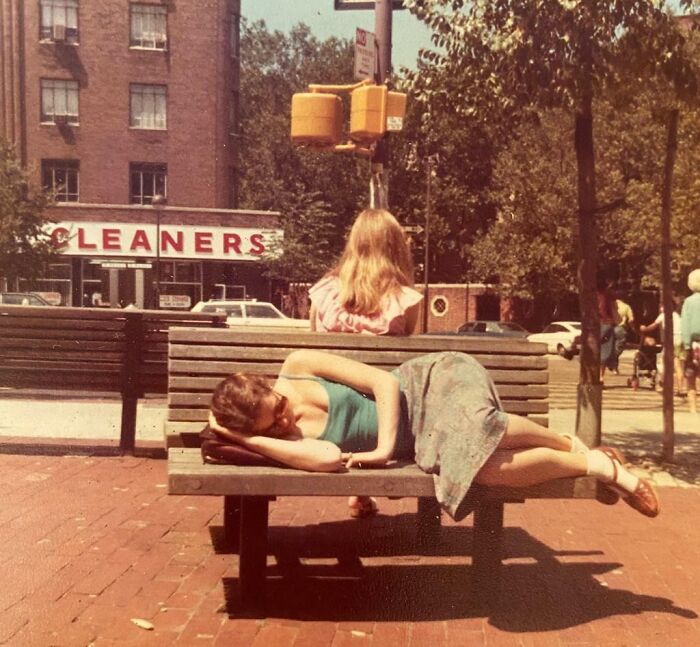 Vintage vacation pic showing woman lying on a bench in a sunny urban park before cell phones had cameras.