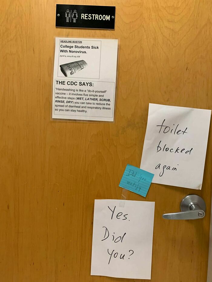 Restroom door with passive-aggressive notes about a blocked toilet and handwashing advice from the CDC.