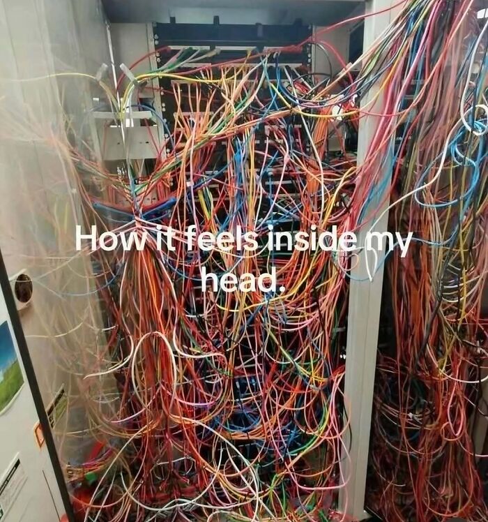 Tangled colorful wires inside a server cabinet illustrating chaos, representing introvert memes after socializing.