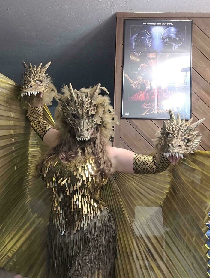 Person dressed in a creative Halloween costume with golden dragon masks and winged outfit for costume ideas inspiration.