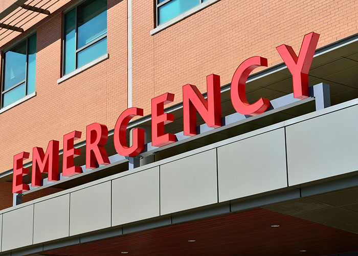Emergency hospital entrance sign on a building exterior, related to urgent care for mother poisoned me incidents.