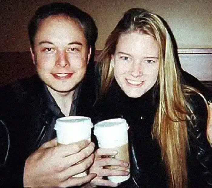 Elon Musk with his transgender daughter smiling and holding coffee cups together in a casual setting. Elon Musk with his transgender daughter smiling and holding coffee cups together in a casual setting.