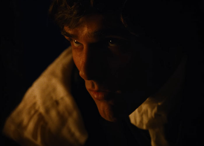 Close-up of Jacob Elordi in dark lighting, portraying a moody character in the Wuthering Heights teaser film.