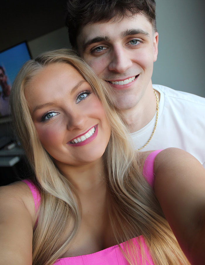 Young cheerleader and her partner smiling closely in a selfie, highlighting the cheerleader dropping out of university news.