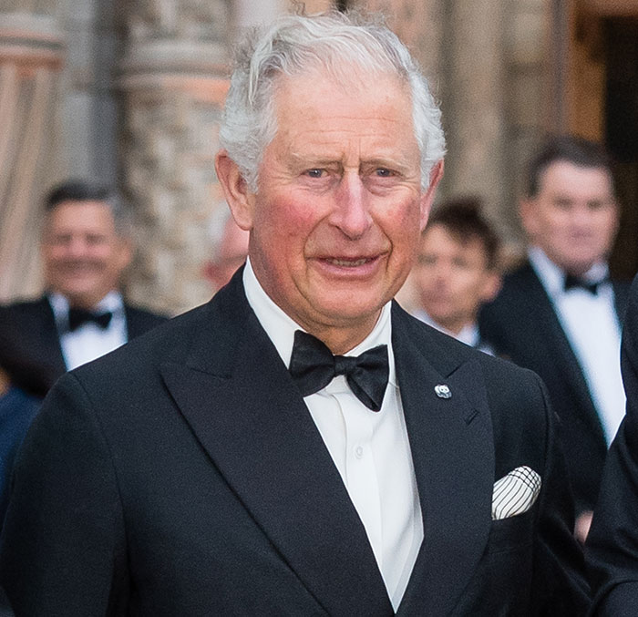 King Charles dressed in a black tuxedo at a formal event after a royal funeral with a solemn expression.