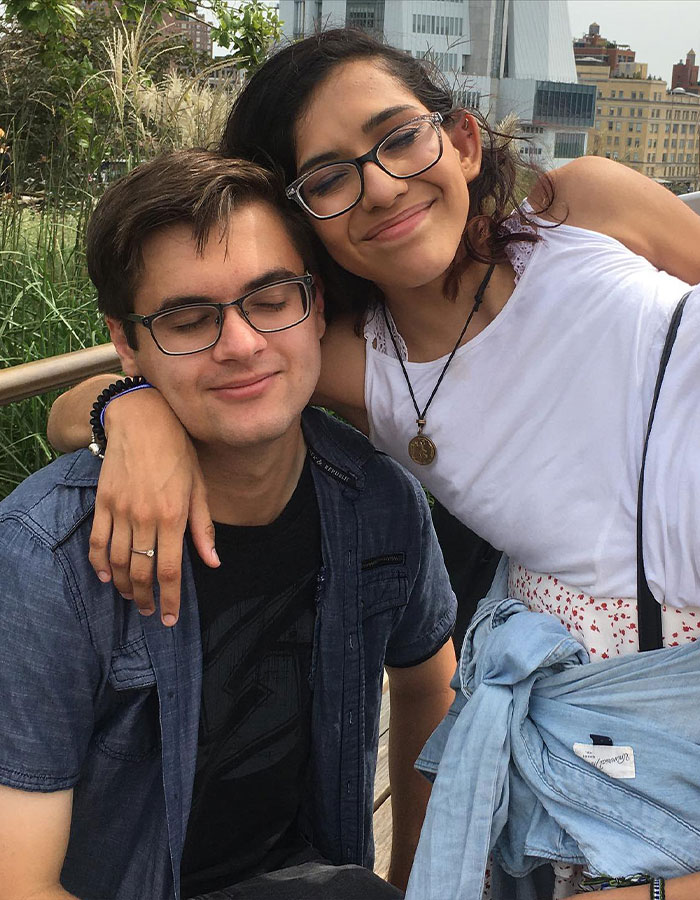 Conjoined twin Carmen Andrade smiling with her husband outdoors, showing affection and closeness in an urban setting.