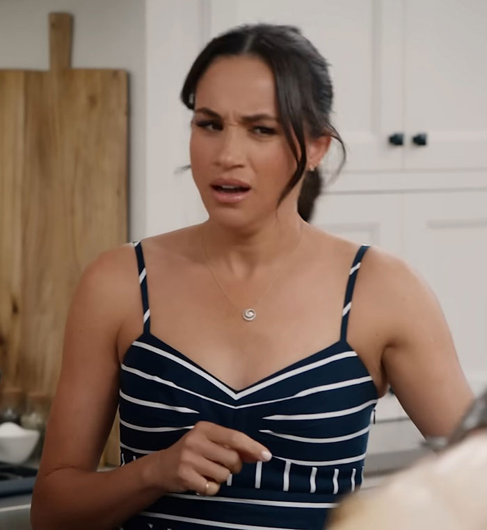 Woman in a striped dress with a confused expression reacting to reality TV star lashing out at Meghan Markle unappreciative claims.