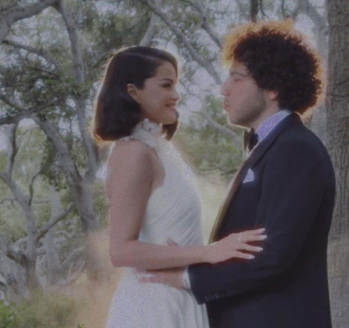 Selena Gomez and partner embracing outdoors at wedding, with Taylor Swift stealing the spotlight with her speech.