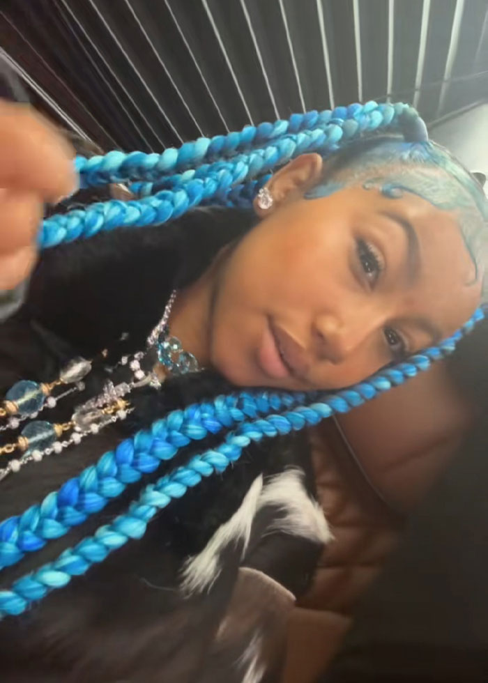 Young woman with bright blue braided hair and jewelry, representing Kanye West's public betrayal list SEO keywords.