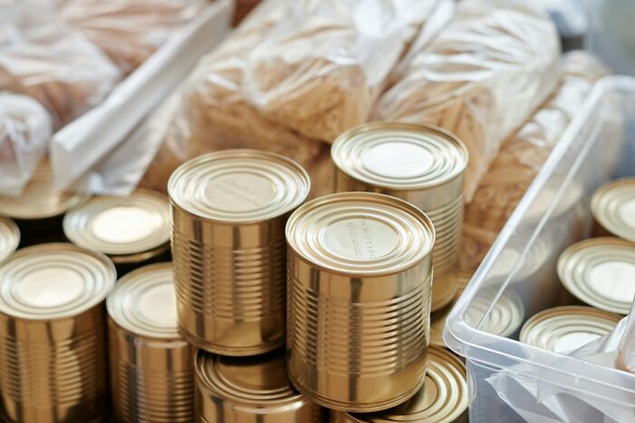 Stack of canned goods and packaged food items representing everyday skills for adulting and food preparedness.