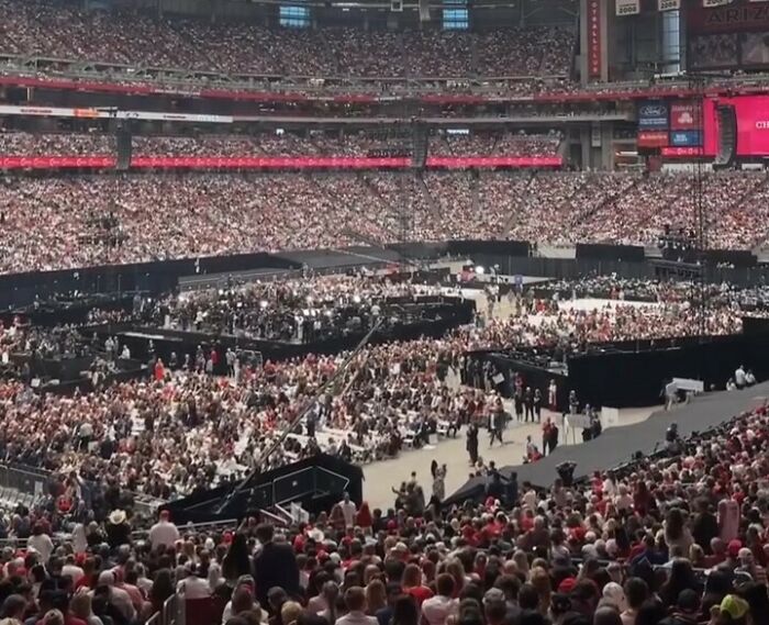 Massive crowd gathered in a large stadium, illustrating mass fury compared to historic events like MLK and JFK funerals.