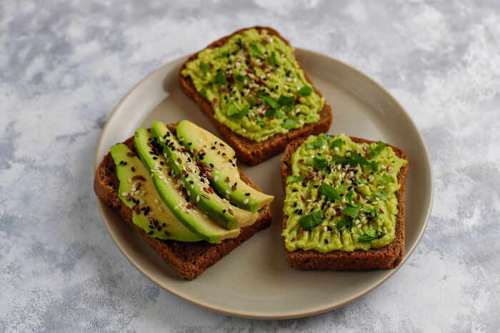 Three slices of avocado toast on a plate, highlighting simple food as a common dealbreaker in relationships.