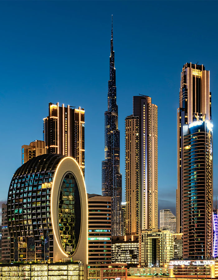 Dubai skyline at dusk featuring Burj Khalifa and illuminated modern skyscrapers in the city center. Dubai skyline at dusk featuring Burj Khalifa and illuminated modern skyscrapers in the city center.
