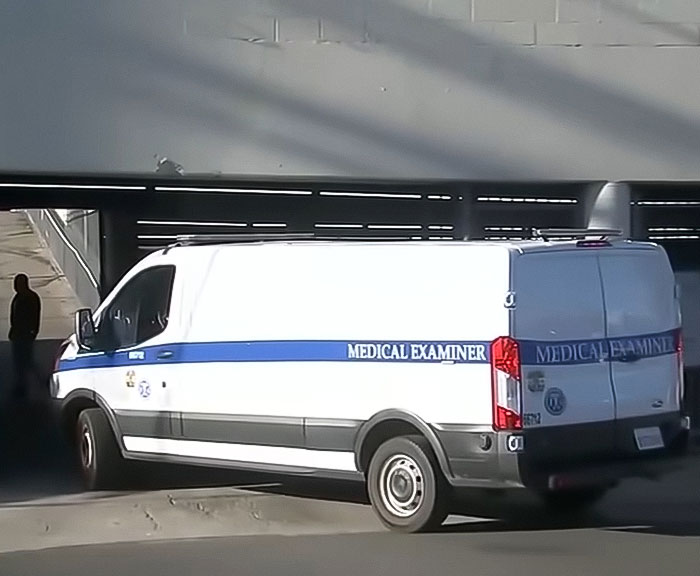 Medical examiner van parked under a bridge near an abandoned Tesla linked to a singer in a decomposing body case.