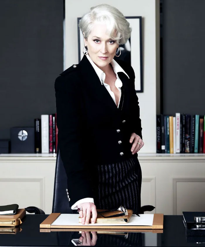 Meryl Streep portraying a powerful fashion editor in a black suit, representing themes from The Devil Wears Prada.