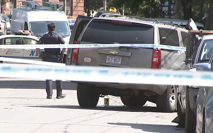 Police officer standing near a taped-off gray SUV involved in a maniac driver case after running over a teen in the street. Police officer standing near a taped-off gray SUV involved in a maniac driver case after running over a teen in the street.