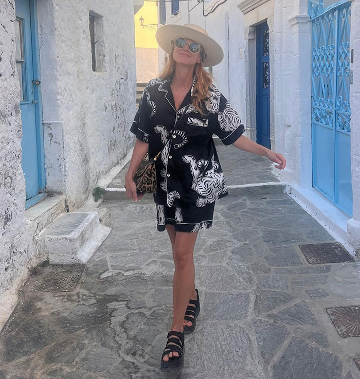 51-year-old 90s star walking in a printed outfit and hat, showcasing her toned body and fitness secrets outdoors.