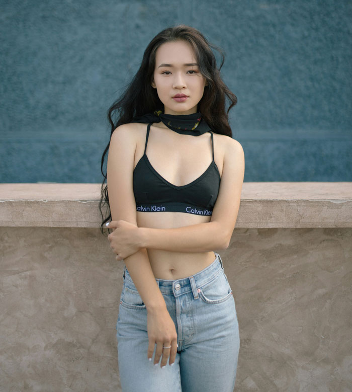 Young woman posing casually outside, embodying the style and vibe of professors who left funny impressions on students.