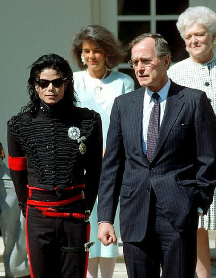 Michael Jackson standing beside George H.W. Bush, with others in background, related to Priscilla Presley on Lisa Marie and Michael's intimate life.