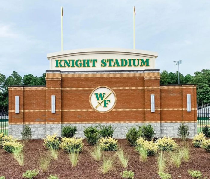 Knight Stadium entrance at school linked to teacher arrested for using poop spray causing repairs and sickness.