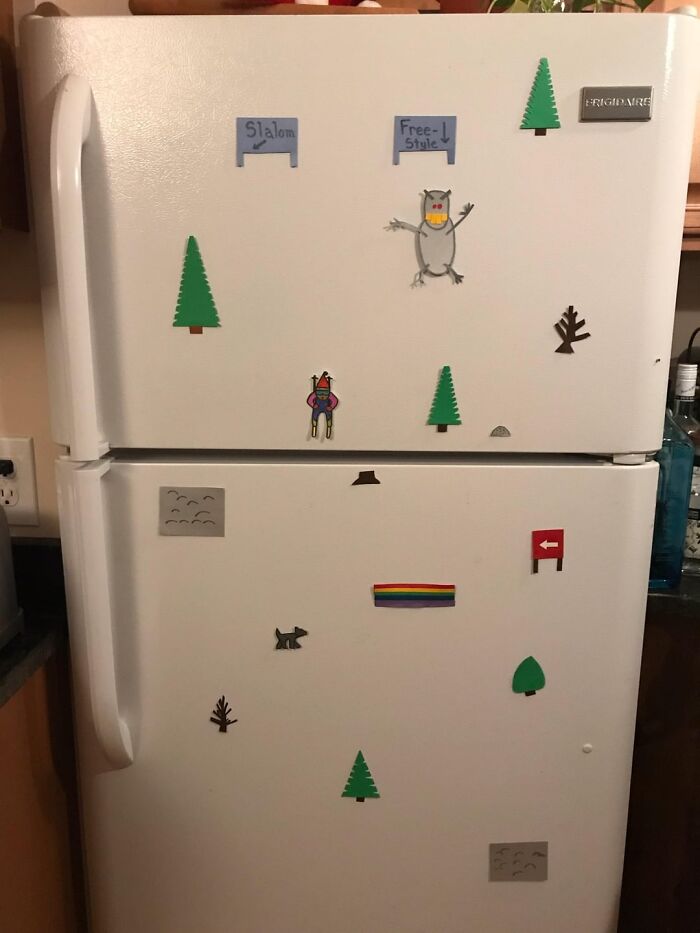 Wholesome magnets on a white fridge, including trees, animals, and signs, creating a playful and distracting scene.
