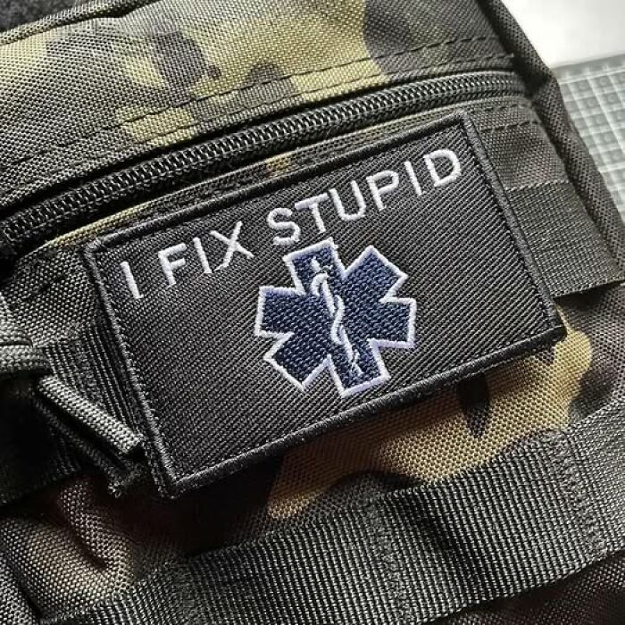 Patch on camouflage bag with medical symbol and text I fix stupid, representing EMT and paramedic humor.