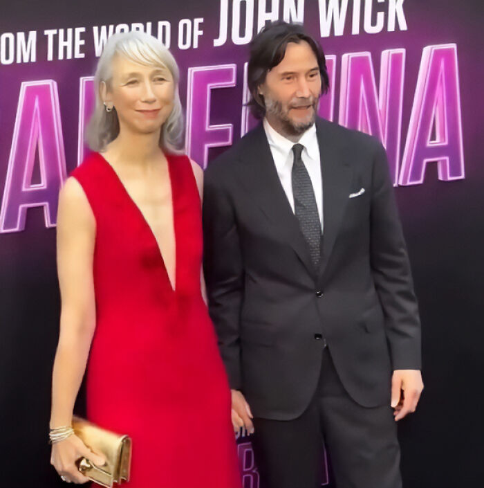 Keanu Reeves and his girlfriend posing at a movie premiere, addressing marriage rumors in a public setting.