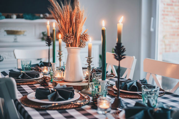 Cozy dining table with lit candles and a rustic centerpiece, creating a warm and inviting atmosphere.