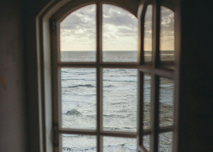 View of ocean waves through an open window revealing hidden gems discovered after moving into new homes