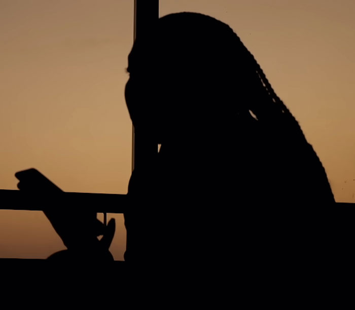 Silhouette of a young woman speaking out about the horror of Dubai's infamous porta potty parties at sunset.